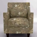 Upholstered accent armchair with beige and olive botanical animal print fabric, square arms, cushioned seat, and wooden legs in a studio setting