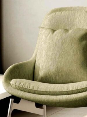 Soft olive green sofa upholstery fabric on cushioned lounge chair with smooth textured finish for modern living room seating
