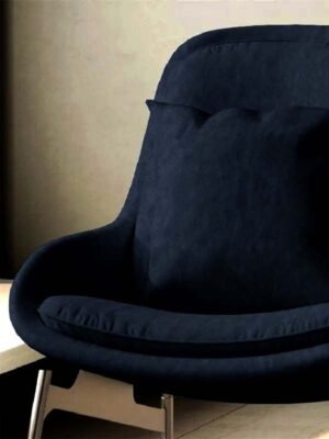 Dark navy blue upholstered lounge chair with cushioned seat and curved backrest on metal legs in a modern interior setting