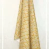 Yellow and beige ikat pattern curtain fabric with geometric motifs, ethnic-inspired designer curtains for modern Indian interiors.