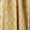 Yellow and beige ikat pattern curtain fabric with geometric motifs, ethnic-inspired designer curtains for modern Indian interiors.
