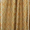 Yellow and beige ikat pattern curtain fabric with geometric motifs, ethnic-inspired designer curtains for modern Indian interiors.