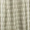 Olive green ikat pattern curtain fabric with subtle ethnic motifs on a neutral base, designer curtains for modern Indian interiors.