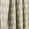 Olive green ikat pattern curtain fabric with subtle ethnic motifs on a neutral base, designer curtains for modern Indian interiors.