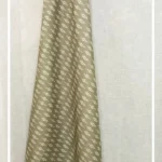 Olive green ikat pattern curtain fabric with subtle ethnic motifs on a neutral base, designer curtains for modern Indian interiors.