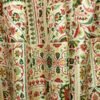 Traditional floral printed curtain fabric with red and green Persian motifs on beige cotton base, elegant decorative drapery fabric for living room and bedroom interiors