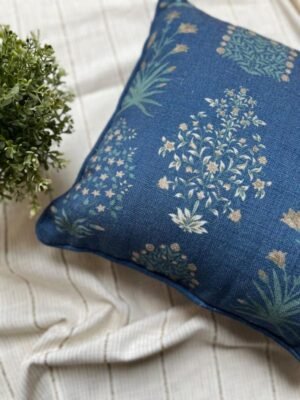 Luxury blue floral cushion cover fabric with delicate botanical motifs in soft green and beige, styled on neutral bedding for premium interior décor.
