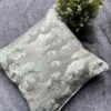 Luxury abstract textured cushion cover fabric in soft sage green with subtle metallic sheen, styled for elegant modern interiors.