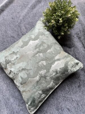 Luxury abstract textured cushion cover fabric in soft sage green with subtle metallic sheen, styled for elegant modern interiors.