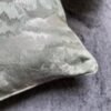 Luxury abstract textured cushion cover fabric in soft sage green with subtle metallic sheen, styled for elegant modern interiors.