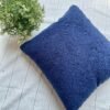 Luxury navy blue textured cushion upholstery fabric with plush boucle finish, styled on a neutral base with greenery for premium interiors
