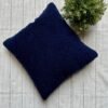 Luxury navy blue textured cushion upholstery fabric with plush boucle finish, styled on a neutral base with greenery for premium interiors