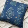 Luxury blue floral cushion cover fabric with delicate botanical motifs in soft green and beige, styled on neutral bedding for premium interior décor.