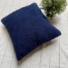 Luxury navy blue textured cushion upholstery fabric with plush boucle finish, styled on a neutral base with greenery for premium interiors