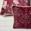 Luxury maroon floral cushion cover fabric with intricate teal and ivory botanical motifs, styled for elegant premium interiors.