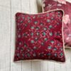 Luxury maroon floral cushion cover fabric with intricate teal and ivory botanical motifs, styled for elegant premium interiors.