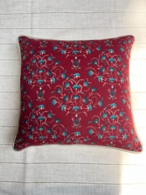 Luxury maroon floral cushion cover fabric with intricate teal and ivory botanical motifs, styled for elegant premium interiors.