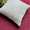 Luxury textured cushion cover fabric in soft pearl silver with subtle metallic sheen, styled on a rich burgundy surface for premium modern interiors.