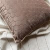 Luxury taupe geometric cushion cover fabric with elegant hexagon texture, styled on neutral bedding for premium modern interiors.