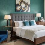 Modern living room interior with teal textured wallpaper accent wall, grey sofa, orange armchairs, wooden side tables and contemporary decor – luxury wallpaper design for stylish home interiors.