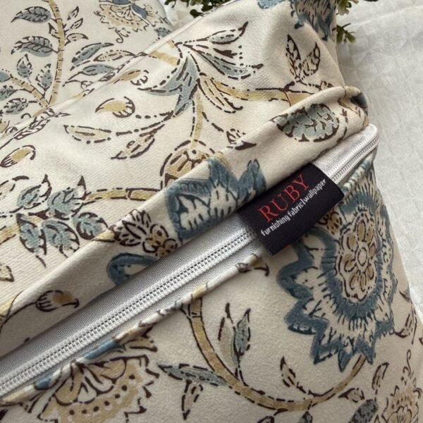 Luxury cream cushion covers with elegant blue floral and vine pattern in premium woven fabric, styled for sophisticated living room and bedroom interiors.