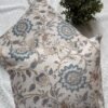 Luxury cream cushion covers with elegant blue floral and vine pattern in premium woven fabric, styled for sophisticated living room and bedroom interiors.