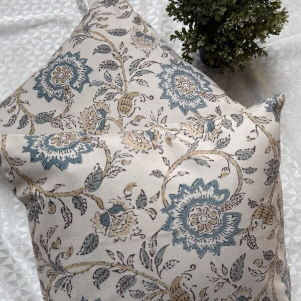 Luxury cream cushion covers with elegant blue floral and vine pattern in premium woven fabric, styled for sophisticated living room and bedroom interiors.