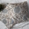 Luxury cream cushion covers with elegant blue floral and vine pattern in premium woven fabric, styled for sophisticated living room and bedroom interiors.