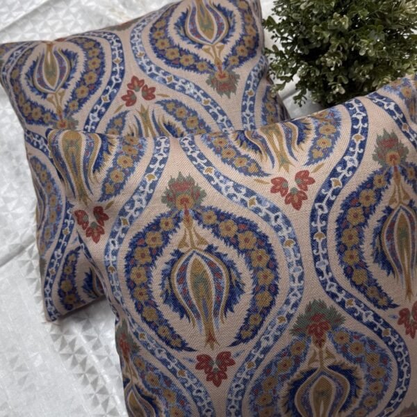 Luxury paisley cushion covers in beige and royal blue with intricate floral motifs, premium woven fabric decorative pillows for elegant living room and bedroom interiors.