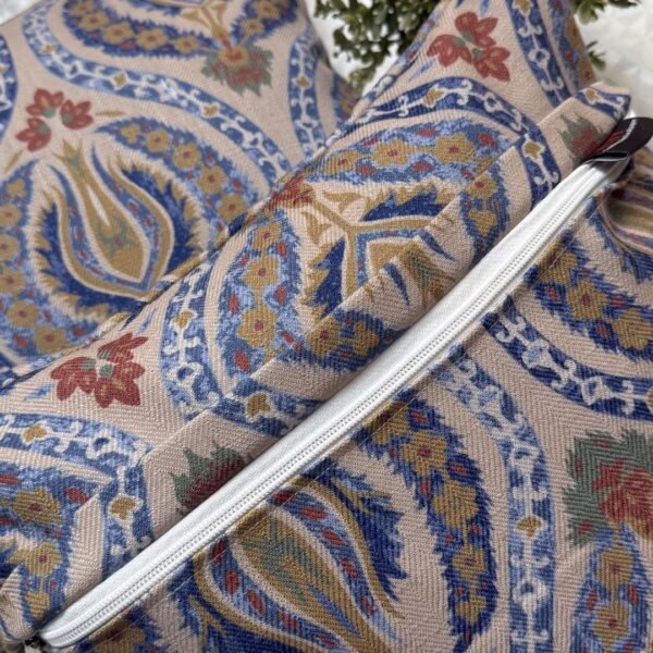 Luxury paisley cushion covers in beige and royal blue with intricate floral motifs, premium woven fabric decorative pillows for elegant living room and bedroom interiors.