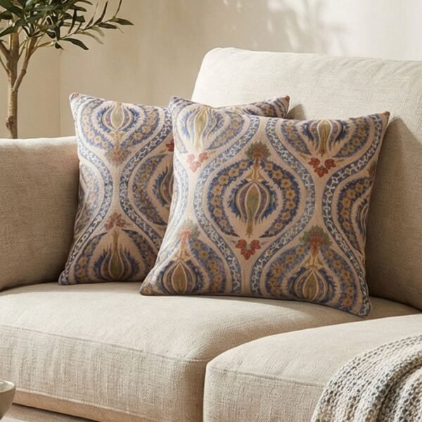 Luxury paisley cushion covers in beige and royal blue with intricate floral motifs, premium woven fabric decorative pillows for elegant living room and bedroom interiors.