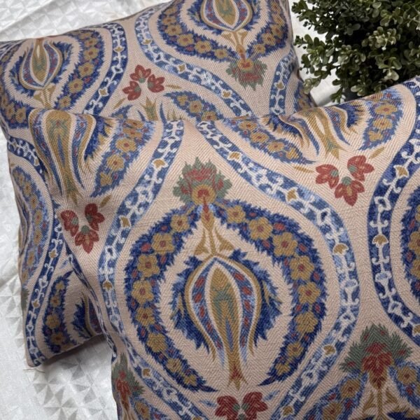 Luxury paisley cushion covers in beige and royal blue with intricate floral motifs, premium woven fabric decorative pillows for elegant living room and bedroom interiors.