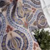 Luxury paisley cushion covers in beige and royal blue with intricate floral motifs, premium woven fabric decorative pillows for elegant living room and bedroom interiors.