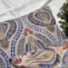 Luxury paisley cushion covers in beige and royal blue with intricate floral motifs, premium woven fabric decorative pillows for elegant living room and bedroom interiors.