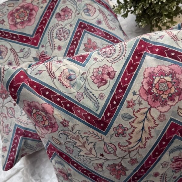 Luxury botanical cushion cover featuring intricate floral motifs in soft sage, blush, and deep crimson with geometric accents, perfect for premium interiors and designer styling.