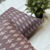 Luxury mauve ikat pattern cushion covers in premium woven fabric, styled on a soft neutral surface with modern décor accents for elegant living room interiors.