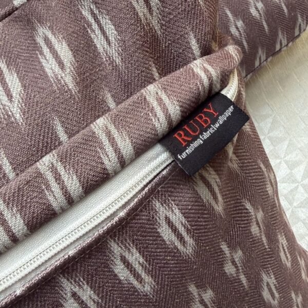 Luxury mauve ikat pattern cushion covers in premium woven fabric, styled on a soft neutral surface with modern décor accents for elegant living room interiors.