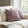 Luxury mauve ikat pattern cushion covers in premium woven fabric, styled on a soft neutral surface with modern décor accents for elegant living room interiors.