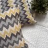 Luxury mustard and grey chevron designer cushion covers in premium fabric placed on white textured bedding, modern bespoke home decor accent pillows