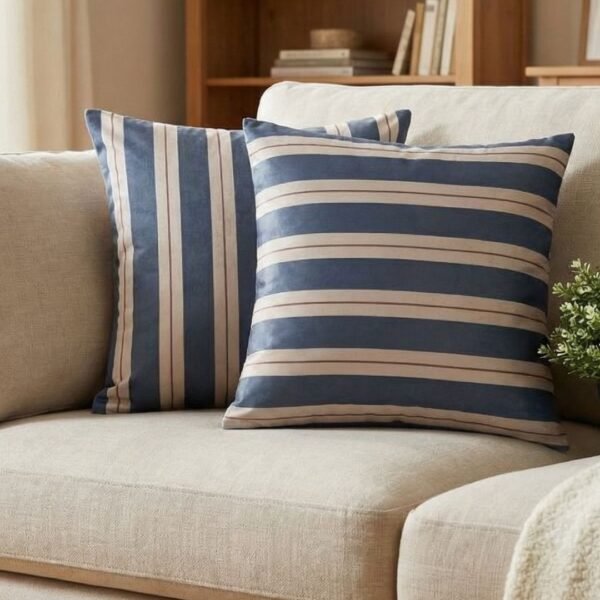Luxury navy and ivory striped designer cushion covers styled against textured geometric wallpaper with decorative greenery, premium modern interior styling inspiration.