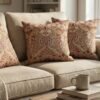 Designer woven cushion cover in warm terracotta and rust tones with cream floral paisley pattern, luxury bespoke pillow for premium living room decor