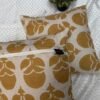 Mustard floral designer cushion covers in premium beige textured fabric with concealed zipper closure, styled for luxury modern interiors.