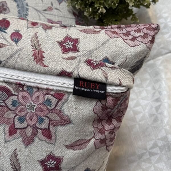 Luxury floral cushion cover in beige woven fabric with pink, burgundy and blue botanical pattern, premium soft furnishing accent for elegant living room and bedroom interiors.