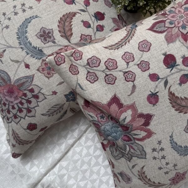 Luxury floral cushion cover in beige woven fabric with pink, burgundy and blue botanical pattern, premium soft furnishing accent for elegant living room and bedroom interiors.