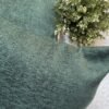 Luxury sage green textured cushion cover in premium woven fabric with subtle chevron pattern, elegant soft furnishing for modern living room and upscale interiors.