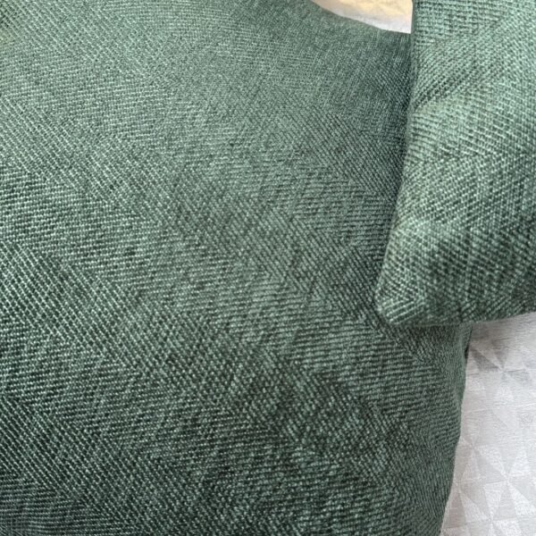 Luxury sage green textured cushion cover in premium woven fabric with subtle chevron pattern, elegant soft furnishing for modern living room and upscale interiors.
