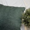 Luxury sage green textured cushion cover in premium woven fabric with subtle chevron pattern, elegant soft furnishing for modern living room and upscale interiors.