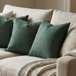 Luxury sage green textured cushion cover in premium woven fabric with subtle chevron pattern, elegant soft furnishing for modern living room and upscale interiors.