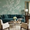 Elegant sage green floral mural wallpaper with white botanical branches and birds in a modern living room with teal sofa, wooden accents, and neutral décor