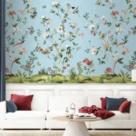 Daisy Bennett floral bird mural wallpaper on soft blue background in elegant bedroom with upholstered bed, pastel cushions and classic wooden side tables
